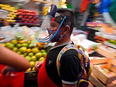 A boy wears a face mask at the San Cosme market in Mexico City on August 10, 2020 amid the COVID-19 novel coronavirus pandemic.