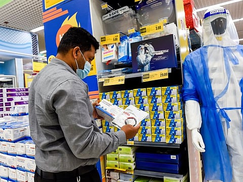 A resident checks out face masks and disposable gloves at a dedicated section at the Lulu Hypermarket in Dubai
