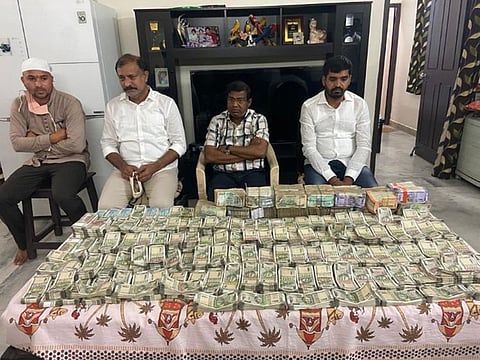 State revenue department officer (second from right) along with three others with piles of currency notes, in the custody of Anti-Corruption Bureau in Hyderabad.  