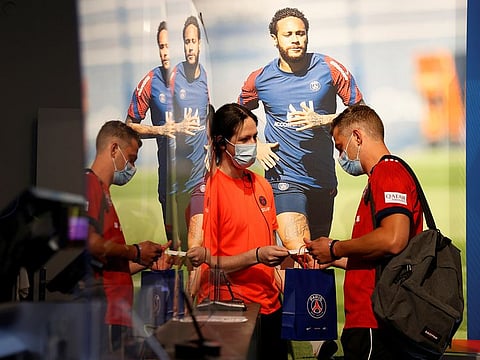 A fan buys a club shirt in the PSG store in Paris ahead of the Champions League final against Bayern Munich 