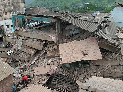 A man removes the debris after a five-storey building collapsed in Raigad in the western state of Maharashtra, India, August 24, 2020. REUTERS/Stringer