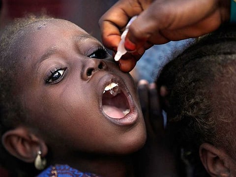 In this Sunday, Aug. 28, 2016 file photo, a health official administers a polio vaccine to a child at a camp for people displaced by militants, in Maiduguri, Nigeria. Health authorities on Tuesday, Aug. 25, 2020 declared the African continent free of the wild poliovirus after decades of effort, though cases of vaccine-derived polio are still sparking outbreaks of the paralyzing disease in more than a dozen countries. 