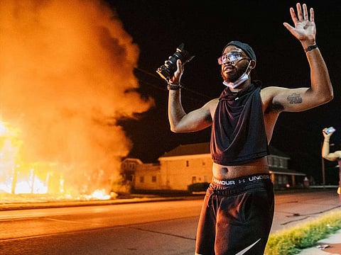 A man walks towards law enforcement with a camera in his hands up on August 24, 2020 in Kenosha, Wisconsin. A second night of civil unrest occurred after the shooting of Jacob Blake, 29, on August 23. Blake was shot multiple times in the back by Wisconsin police officers after attempting to enter into the drivers side of a vehicle.  
