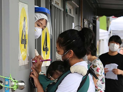 A medical worker, top left, guides people during the COVID-19 testing at a makeshift clinic in Seoul, South Korea, Wednesday, Aug. 26, 2020. Health officials in South Korea called on thousands of striking doctors to return to work as the country counted its 13th straight day of triple-digit daily jumps in coronavirus cases.