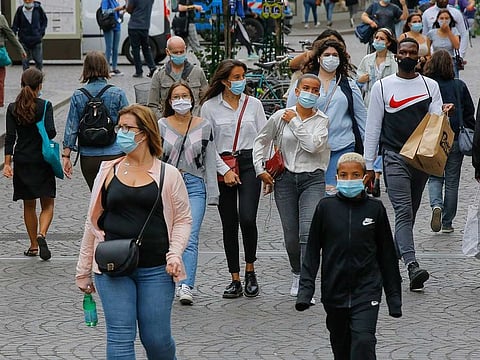 Paris: People walk in a shopping area while wearing a protective face masks 