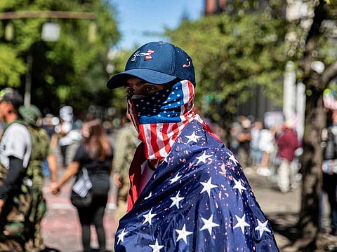 A man dressed in an American flag joins protesters in Portland, Oregon, U.S., August 22, 2020. 