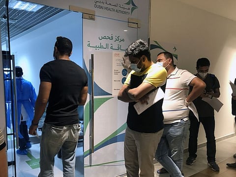Residents queue up outside the Knowledge Village Medical Fitness Centre for visa medical tests. 