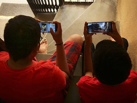 File photo: Children play online game PUBG on their mobile phones.