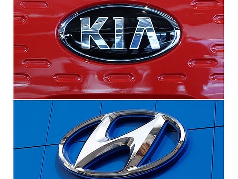 This combination of file photos shows the logo of Kia Motors during an unveiling ceremony on Dec. 13, 2017, in Seoul, South Korea, top, and a Hyundai logo on the side of a showroom on April 15, 2018, in the south Denver suburb of Littleton, Colo., bottom. The Korean automakers are recalling over 591,000 vehicles in the U.S. to fix a brake fluid leak that could cause engine fires.