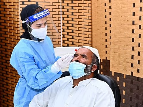 A health worker tests a UAE resident for COVID-19.