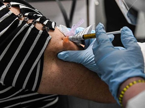 In this file photo taken on August 13, 2020, Sandra Rodriguez, 63, receives a COVID-19 vaccination test from Yaquelin De La Cruz at the Research Centers of America (RCA) in Hollywood, Florida. The Trump administration has urged US states to get ready to distribute a potential Covid-19 vaccine by November 1. 
