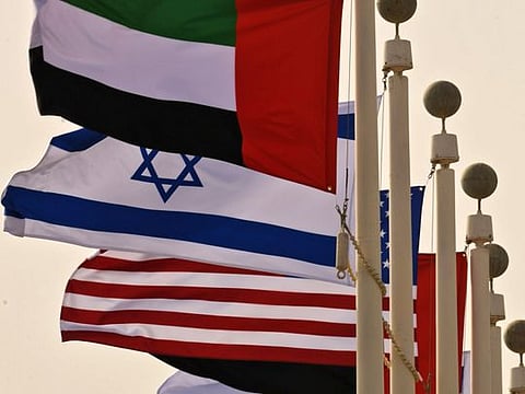 The Emirati, Israeli and US flags sway in the wind at the Abu Dhabi airport at the arrival  of the first-ever commercial flight from Israel to the UAE, on August 31, 2020. - A US-Israeli delegation including White House advisor Jared Kushner took off on a historic first direct commercial flight from Tel Aviv to Abu Dhabi to mark the normalisation of ties between the Jewish state and the UAE