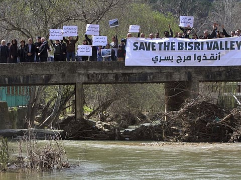 In this file picture, Lebanese protesters hold placards during a protest against the Bisri dam project, in the Bisri Valley, 58km southeast of Beirut on March 10, 2019. 