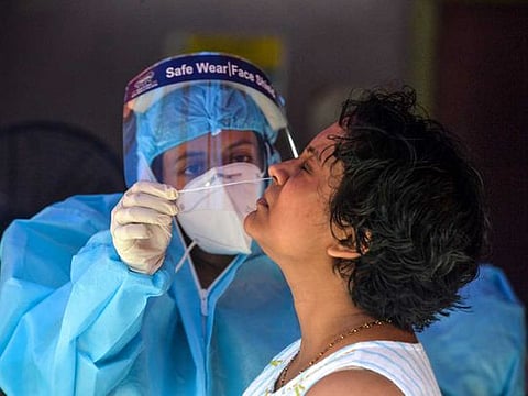 A health official collects nasal swab samples from a woman for a COVID-19 coronavirus test at a primary health centre in Siliguri, West Bengal, on September 5, 2020. 