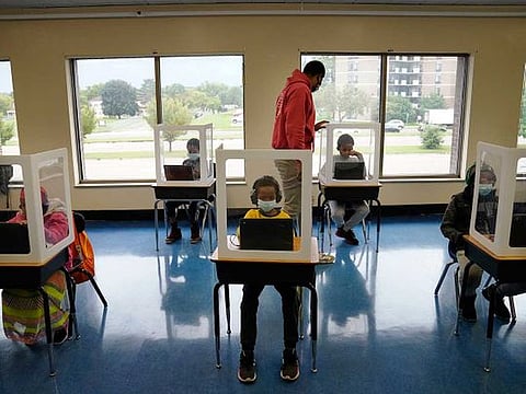  Paraprofessional Jaevon Walton, centre, reminds a student to wear his face mask in a learning pod of second through seventh graders at Harvest Best Academy, Tuesday, Sept. 8, 2020, in Minneapolis. 