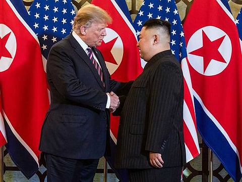 This file photo taken on February 27, 2019 shows US President Donald Trump (L) shaking hands with North Korea's leader Kim Jong Un before a meeting at the Sofitel Legend Metropole hotel in Hanoi.  North Korean leader Kim Jong Un deployed flattery and florid prose in the letters that forged his diplomatic courtship of Donald Trump, according to a new book on the US president on September 10, 2020. 