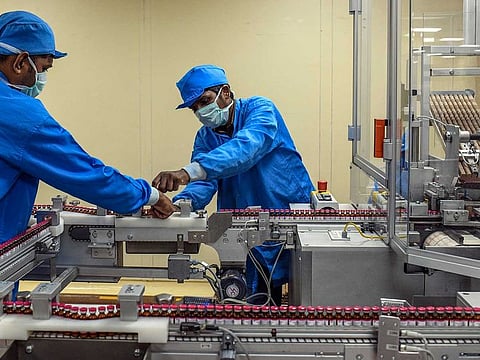Work on a vaccine assembly line at the Serum Institute in Pune, India, on July 10, 2020. The institute has paused trials on the vaccine after its partner AstraZeneca halted tests following an unexplained illness in a study participant.