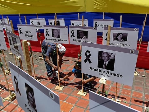 Workers place signs with portraits of health workers who died from COVID-19 at the Venezuelan Medical Federation in Caracas, on September 10, 2020, ahead of a tribute.
