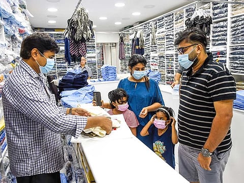 Parents buying school uniform for children at a shop in Sharjah, UAE. 