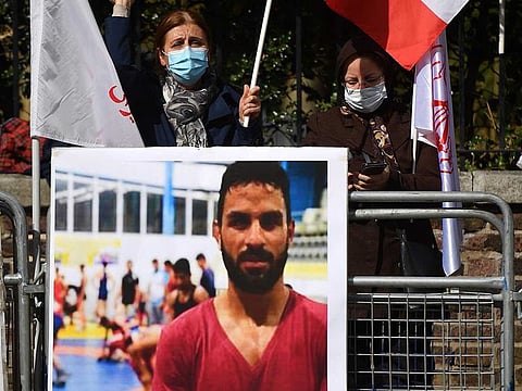 Anti-government ethnic Iranians in exile protest at Tehran's embassy in London with pictures of Afkari.