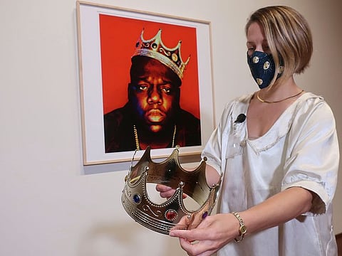 Sotheby's specialist Cassandra Hatton holds the plastic crown worn and signed by the Notorious B.I.G., Monday, Sept. 14, 2020, in New York. 