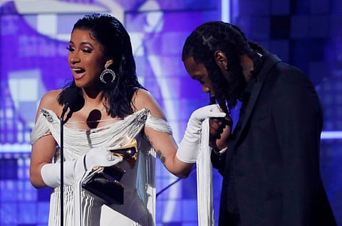 Cardi B accepts the Best Rap Album award for 'Invasion of Privacy' as her husband Offset kisses her hand at the 61st Grammy Awards on February 10, 2019.