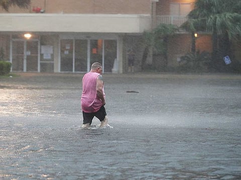 A man walks though a flooded parking lot as the outer bands of Hurricane Sally come ashore on September 15, 2020 in Gulf Shores, Alabama. The storm is bringing heavy rain, high winds and a dangerous storm surge from Louisiana to Florida.  