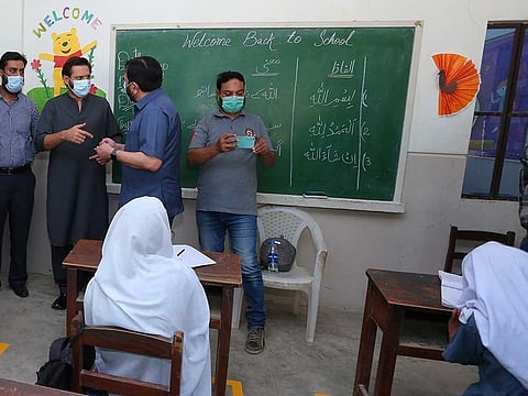 Pakistan cricketer Shahid Afridi along with Zahid Saeed who is CEO of his partner charity, Green Crescent Trust, checks observance of anti-coronavirus SOPs at one of the charitable schools run by his non-profit in Wangi Goth area of Karachi, Pakistan, on Thursday, September 17, 2020.