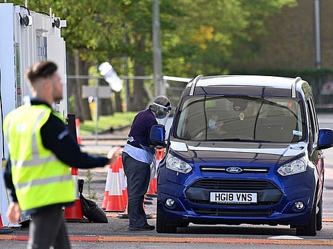 A woman arrives by car as they attend a novel coronavirus drive-in testing centre set up at Lee Valley Athletics Centre in Edmonton, in north London, on September 17, 2020.  