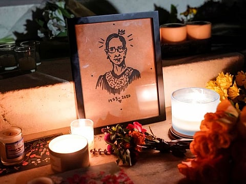 Candles are lit next an illustration of Associate Justice Ruth Bader Ginsburg as people mourn her death at the Supreme Court in Washington on September 19, 2020.