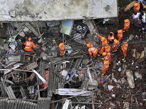 Rescue workers search for survivors in the rubble of a collapsed three-storey residential building in Bhiwandi.