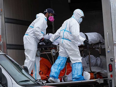 Workers move bodies to a refrigerated truck from the Andrew T. Cleckley Funeral Home in the Brooklyn borough of New York.