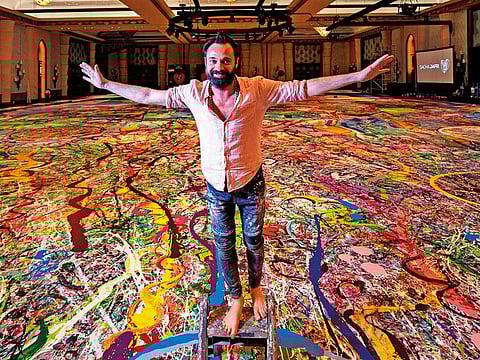 Contemporary British artist Sacha Jafri stands on his record-breaking painting entitled ‘The Journey of Humanity’ in Dubai. With the painting, which measures the size of two football fields, he hopes to raise $30 million to fund health and education initiatives for children living in poverty worldwide.