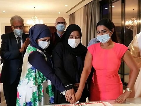 Participants during the ceremony cutting a cake decorated with the Bahraini, UAE and Israeli flags.