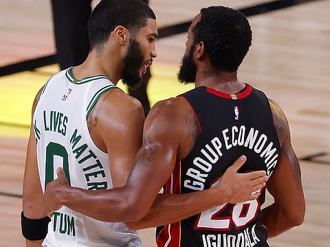 Jayson Tatum of the Boston Celtics congratulates Andre Iguodala of the Miami Heat 