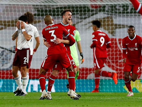 Liverpool's Diogo Jota, centre, is congratulated by teammate Fabinho after scoring his team's third goal.