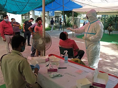A health worker wearing Personal Protective Equipment (PPE) gives a nasal swab to a person for a rapid-antigen methodology Covid-19 test at Sarai Kale Khan Transport Authority in New Delhi, India, on Monday, Sept. 28, 2020. 