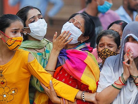 Relatives mourn the death of a man due to the coronavirus disease (COVID-19), at a crematorium in New Delhi, India