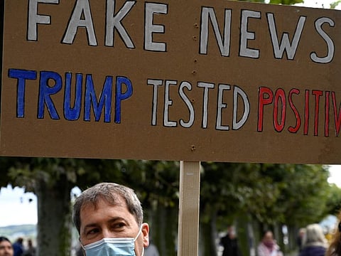 A demonstrator holds up a placard reading 'Fake news in Konstanz, southern Germany, on October 3, 2020.