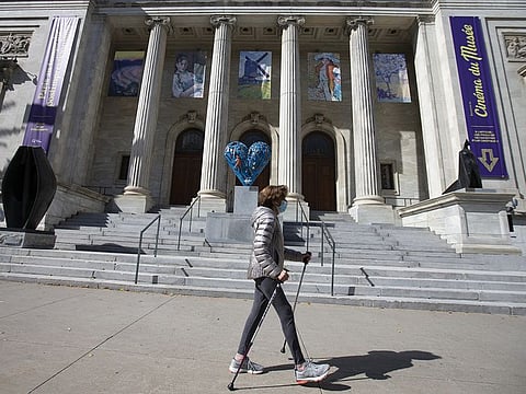 A pedestrian wearing a protective mask walks past the Montreal Museum of Fine Arts in Montreal, Quebec, Canada, on Thursday, Oct. 1, 2020. 