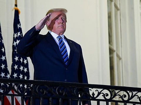 U.S. President Donald Trump salutes as he poses without a face mask on the Truman Balcony of the White House after returning from being hospitalized at Walter Reed Medical Center for coronavirus disease (COVID-19) treatment, in Washington, U.S. October 5, 2020