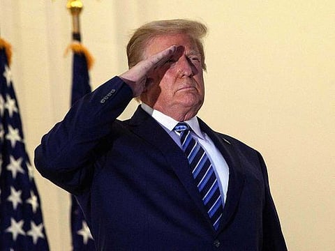 US President Donald Trump salutes from the Truman Balcony in White House