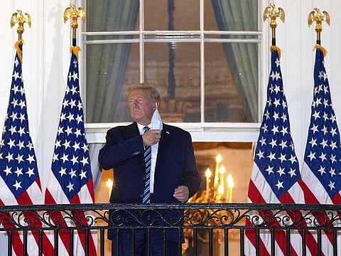 US President Donald Trump removes his mask upon return to the White House from Walter Reed National Military Medical Center on October 05, 2020 in Washington, DC. Trump spent three days hospitalised for coronavirus.  