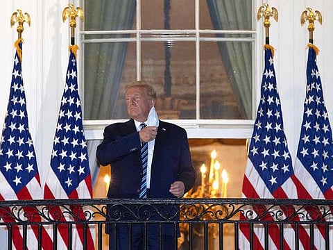 US President Donald Trump removes his mask upon return to the White House from Walter Reed National Military Medical Center on October 05, 2020 in Washington, DC. Trump spent three days hospitalised for coronavirus.  
