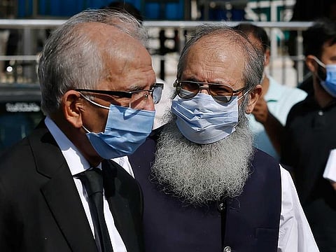 Ahmed Saeed Sheikh, right, father of a British-born militant Ahmed Omar Saeed Sheikh, leaves the Supreme Court with his lawyer Mahmood Ahmed Sheikh, left, after an appeal hearing in the Daniel Pearl case, in Islamabad, Pakistan, Wednesday, Oct. 7, 2020. 