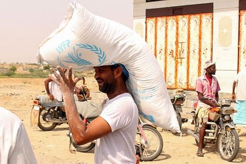 In this file photo taken on July 8, 2019 displaced Yemenis from areas near the border with Saudi Arabia carry World Food Programme food aid.