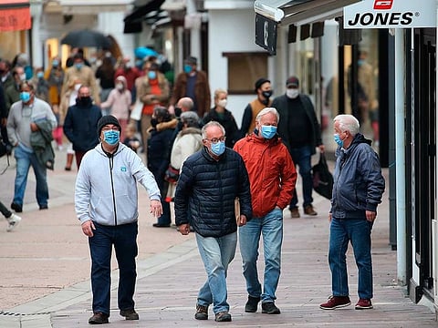 People wearing masks in Saint Jean de Luz, southwestern France.  French President Emmanuel Macron announced a nationwide four-week lockdown, shutting down schools and business, in the latest sign that Europe is yet again losing control of the pandemic.