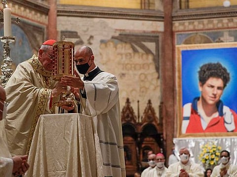 Cardinal Agostino Vallini, left, holds a relic of 15-year-old Carlo Acutis, an Italian boy who died in 2006 of leukemia, during his beatification ceremony celebrated in the St. Francis Basilica, in Assisi, Italy, Saturday, Oct. 10, 2020. 