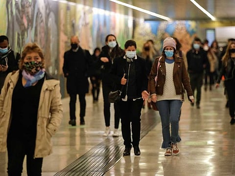 People wear masks to prevent the spread of COVID-19 as they walk in the underground of the Garibaldi railway station, in Milan, Italy