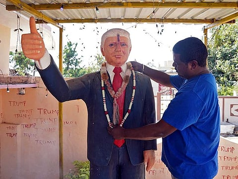 Bussa Krishna, a fan of US President Donald Trump, adjusts a garland on a Trump statue after offering prayers at his house in Konney village in the southern state of Telangana, India, February 14, 2020.